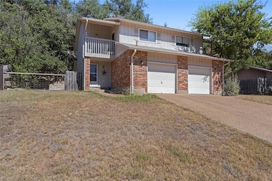 Front of property with brick siding, fence, drive