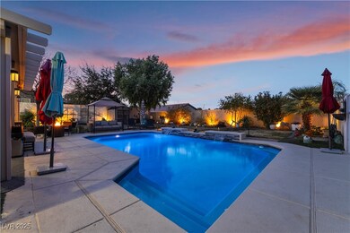 Pool at dusk with a patio and pool water feature