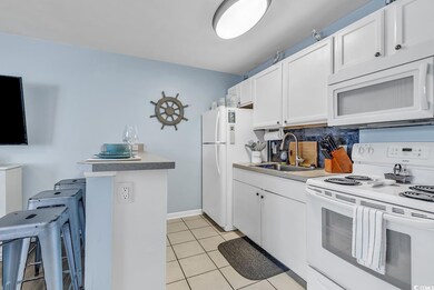 Kitchen featuring white appliances, white cabinets