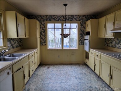 Kitchen featuring sink, white appliances, pendant