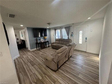 Living area featuring a textured ceiling, visible 
