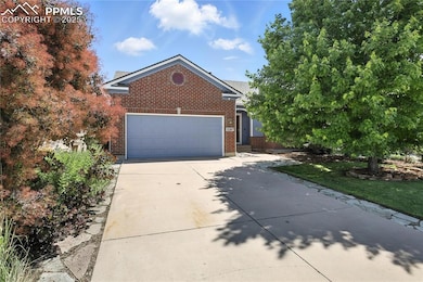 View of front facade featuring concrete driveway, an attached garage, a front yard, and brick siding