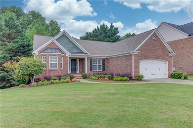 Craftsman house featuring brick siding, an attached garage, roof with shingles, and a front lawn