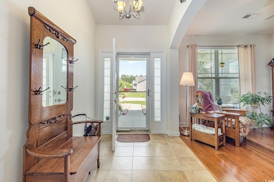 Foyer featuring light tile patterned floors, arche