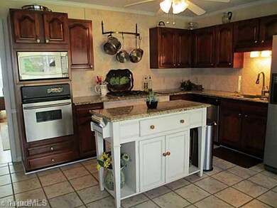 Kitchen. Remodeled with granite tops, SS appliances, work island, tiled floor and backsplash. Eat-in kitchen with fabulous view of the private backyard.