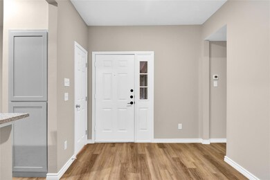 Foyer entrance with baseboards and light wood fini