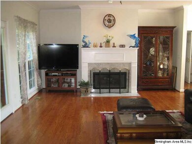 Den with hardwood flooring, opens to screened porc