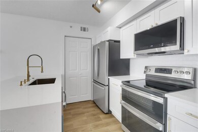 Kitchen with light countertops, white cabinetry, v