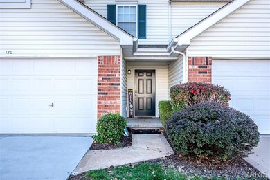 Doorway to property featuring brick siding and a garage