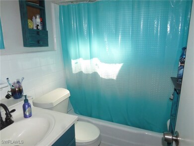 Full bath with tile walls, shower / tub combo with