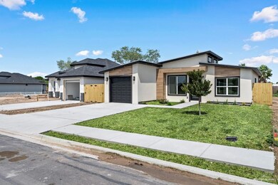 View of front of property with a garage and a front lawn