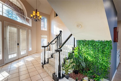 Tiled foyer featuring a textured ceiling, high vau
