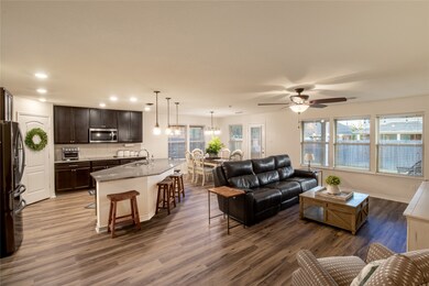 Living area featuring dark wood finished floors, healthy amount of natural light, recessed lighting, and ceiling fan
