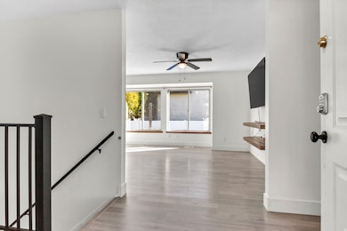Foyer entrance with light wood-style floors and ceiling fan