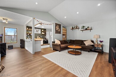 Living room featuring recessed lighting, vaulted ceiling, and light wood finished floors