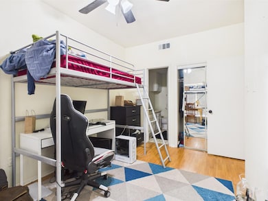 Bedroom featuring an office area, wood finished f