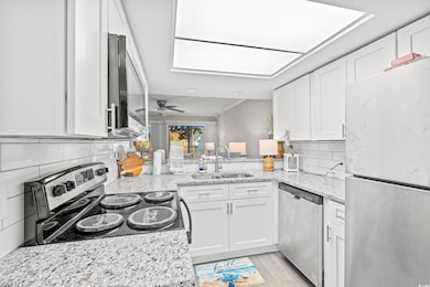 Kitchen featuring a skylight, stainless steel appl