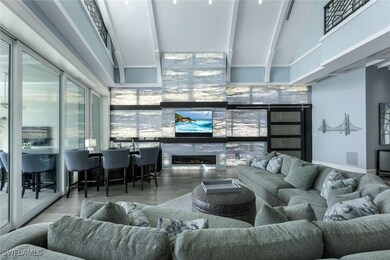 Living area with wood finished floors, a high ceiling, and a glass covered fireplace