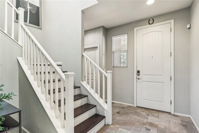 Foyer entrance with stairway, baseboards, and ston