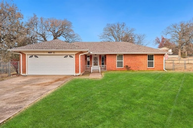 Single story home featuring a garage and a front y