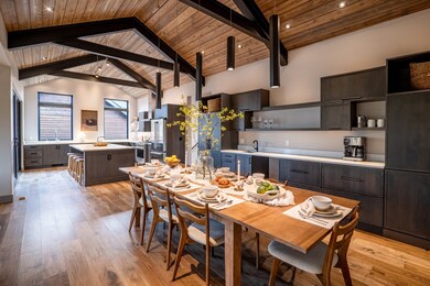 Dining space with wood ceiling, vaulted ceiling with beams, and light wood finished floors