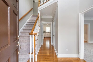 Entryway featuring crown molding, light wood finished floors, and stairs