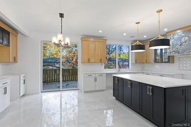 Kitchen featuring backsplash, light stone counters, a chandelier, decorative light fixtures, and recessed lighting