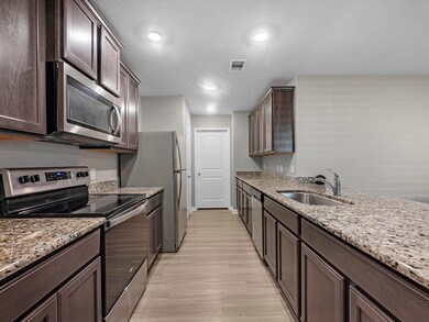 This kitchen has endless storage with plenty of countertop space and cabinets. Stainless steel appliances and fridge included.