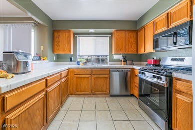 Kitchen with tile countertops, stainless steel app