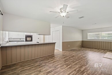 Interior space with ceiling fan, sink, and dark hardwood / wood-style flooring