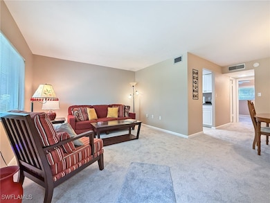 Living area with light carpet, baseboards