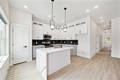 Upgraded kitchen with waterfall countertops, pantr