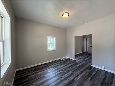 Living room featuring dark wood finished floors and baseboards