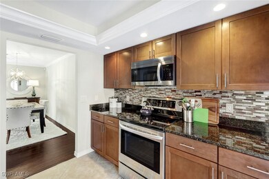 Kitchen with light tile patterned floors, dark sto