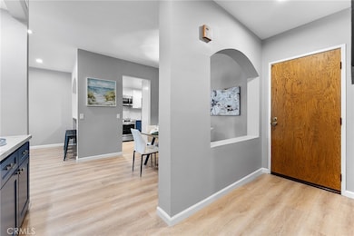 Formal entry with arch see through to the dining room. Newly installed luxury vinyl plank flooring, painted, light fixture, recessed lighting. Left of image is a converted closet into a coffee station or whatever you deem fit.
