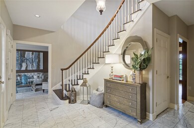 A grand foyer greets you featuring an elegant curv