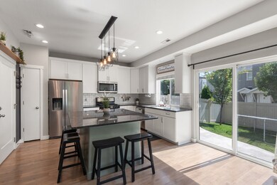 Kitchen with appliances with stainless steel finishes, a kitchen breakfast bar, a kitchen island, white cabinets, and recessed lighting