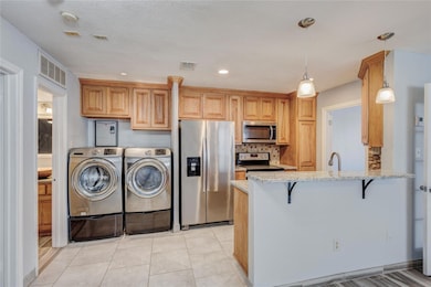 Kitchen featuring light stone counters, visible ve