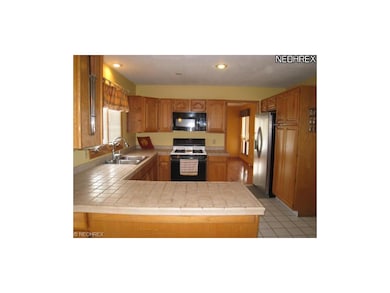 Kitchen offers a pantry and tile countertops.