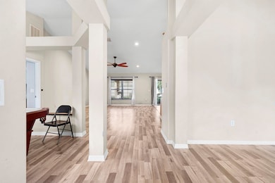 Hall featuring light wood-type flooring, recessed lighting, and a high ceiling