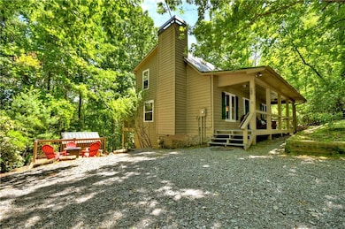View of home's exterior featuring a chimney and a porch, side yard with fire pit