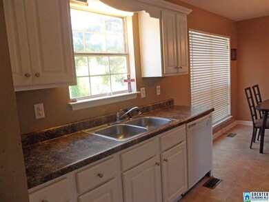 The galley kitchen also overlooks the backyard (yo