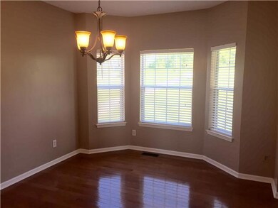 Dining room adjacent to the kitchen with nice oil rubbed bronze light fixture. New hardwood floors too!