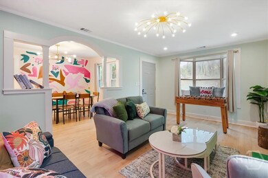 Living room leading to dining room with hand painted feature wall.