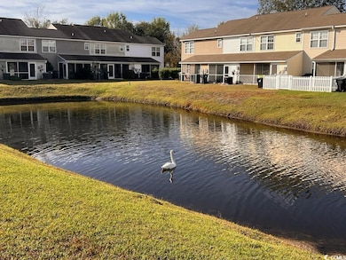 Water view with fence and nearby suburban area