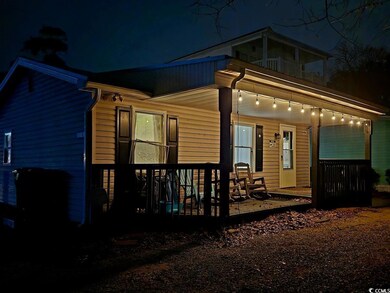 Exterior of House - porch with 3 chairs and 2 rocking chairs, sand toys, 4 beach chairs. Plug in the twinkle lights for a lovely evening glow!