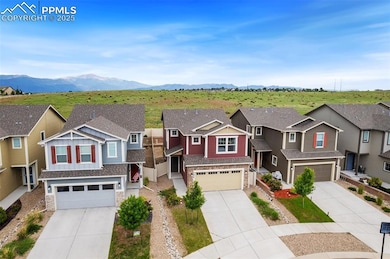 View of front of house featuring stone siding, a garage, and driveway