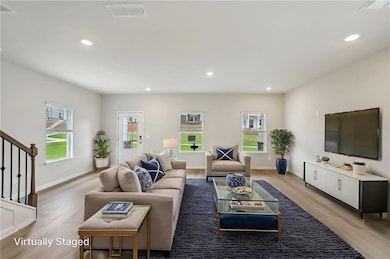 Living area with light wood finished floors, reces