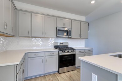Kitchen with gray cabinetry, light hardwood / wood