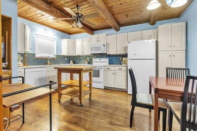 Kitchen with white appliances, a wooden ceiling w